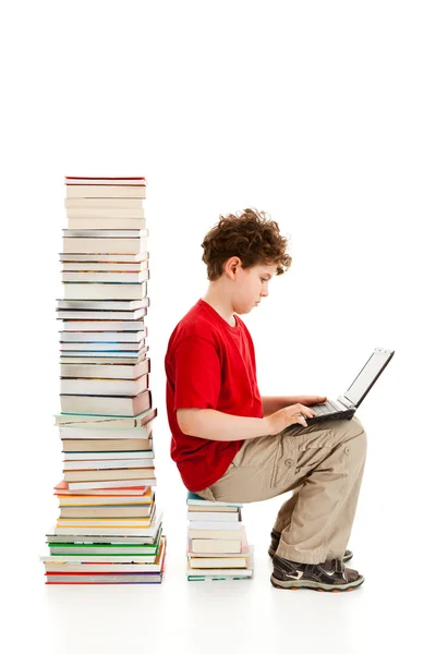 Junge sitzt dicht an Bücherstapel — Stockfoto
