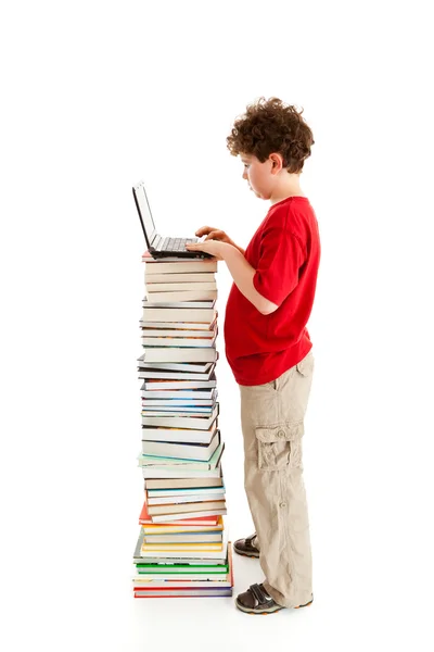 Niño de pie cerca de la pila de libros — Foto de Stock