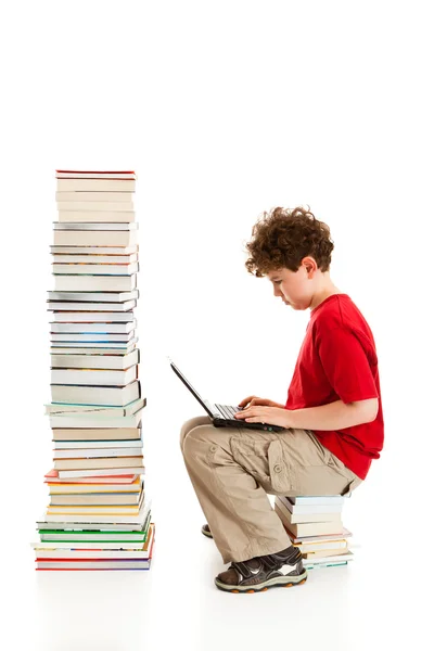 Garçon assis près de pile de livres — Photo