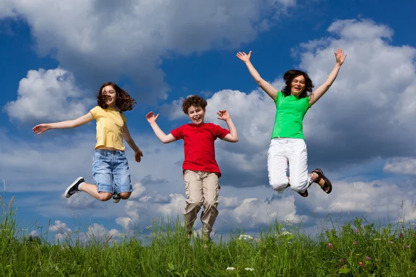 Familia saltando, corriendo al aire libre — Foto de Stock