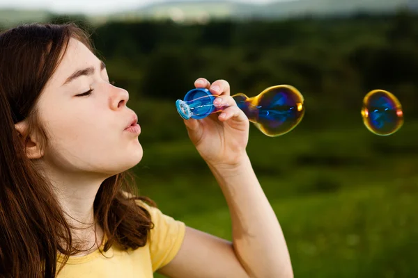 Girl blowing soap bubbles — Stock Photo, Image