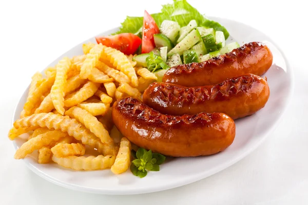 Grilled sausages with chips and vegetables — Stock Photo, Image