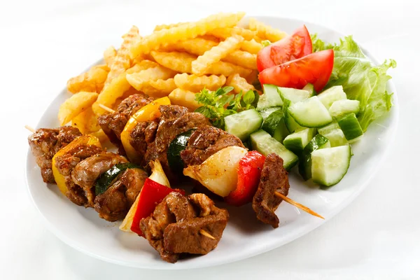 Grilled meat with French fries and vegetable salad — Stock Photo, Image