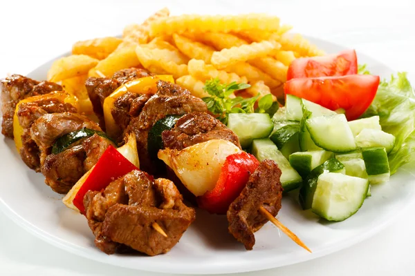 Grilled meat with French fries and vegetable salad — Stock Photo, Image