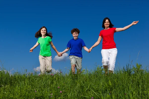 Familie springen, running buiten Stockafbeelding