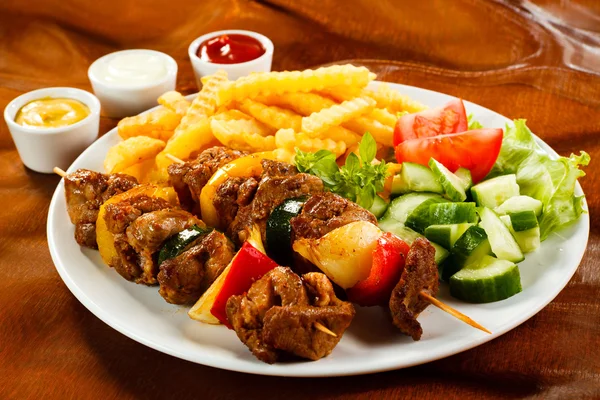 Carne a la parrilla con papas fritas y ensalada de verduras —  Fotos de Stock