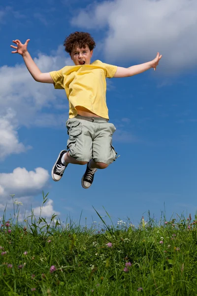 Boy jumping against blue sky — Stock Photo, Image