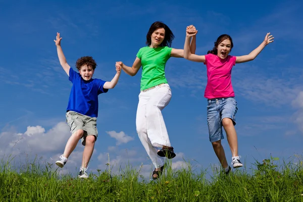 Familia saltando, corriendo al aire libre — Foto de Stock