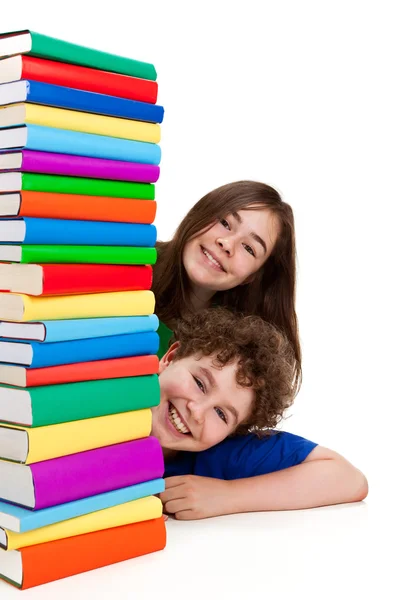 Дети за стопкой книг — стоковое фото