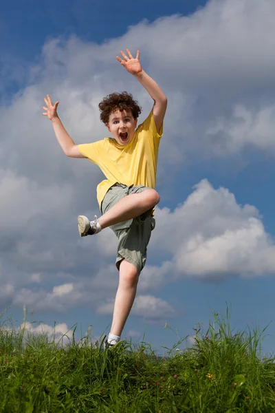 Boy jumping against blue sky Stock Picture