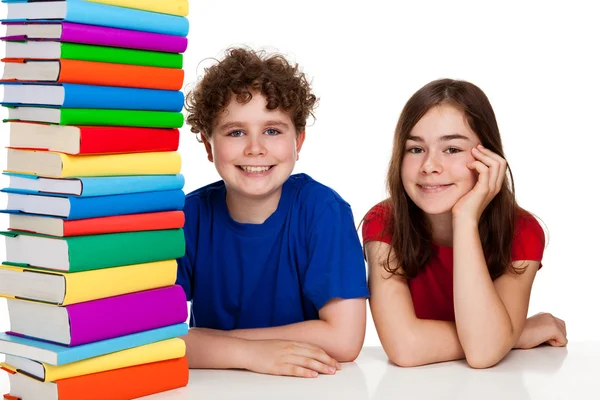 Étudiants assis derrière une pile de livres — Photo