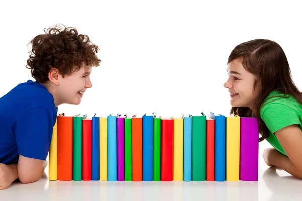 Studenti seduti dietro mucchio di libri — Foto Stock