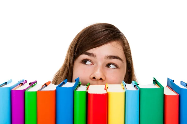 Menina espreitando atrás de pilha de livros — Fotografia de Stock