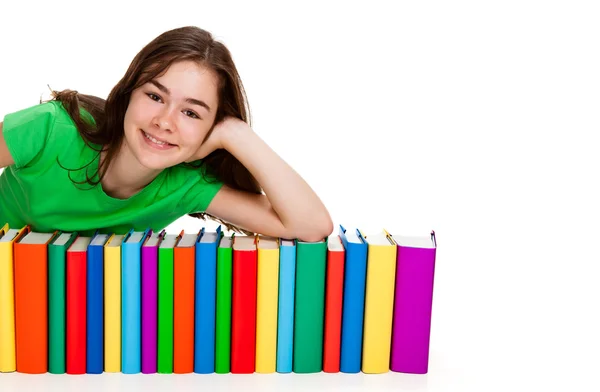 Studentin sitzt neben Bücherstapel — Stockfoto