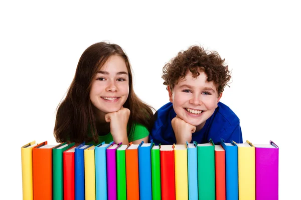 Students sitting behind pile of books — Stock Photo, Image