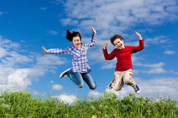 Menina e menino pulando — Fotografia de Stock