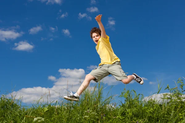 Ragazzo che salta, corre contro il cielo blu — Foto Stock