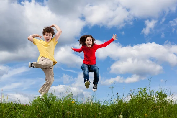 Ragazza e ragazzo salto — Foto Stock