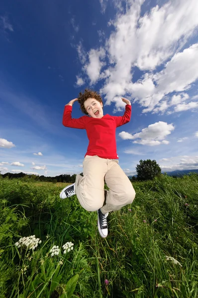 Rapaz a saltar contra o céu azul — Fotografia de Stock