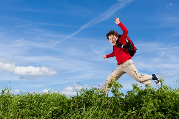 Niño saltando contra el cielo azul —  Fotos de Stock