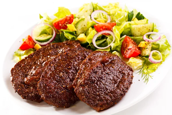 Grilled steaks and vegetable salad — Stock Photo, Image