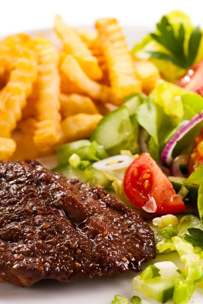 Grilled steaks, French fries and vegetable salad — Stock Photo, Image