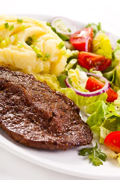 Grilované steaky, vařené brambory a zeleninový salát — Stock fotografie