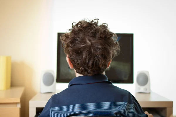 Jongen met computer thuis Rechtenvrije Stockafbeeldingen