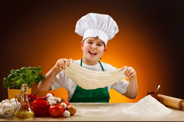 Gutt som lager pizzadeig – stockfoto
