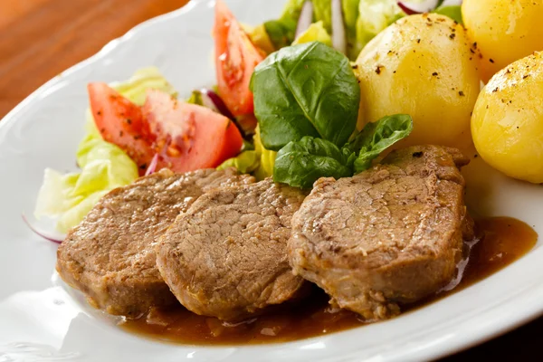 Gegrilde steaks, gebakken aardappelen en groenten — Stockfoto