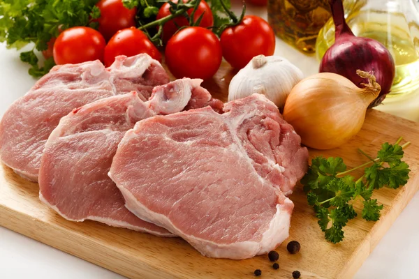 Carne de porco crua na tábua de corte — Fotografia de Stock