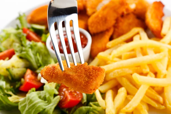 Fried chicken nuggets, French fries and vegetables — Stock Photo, Image