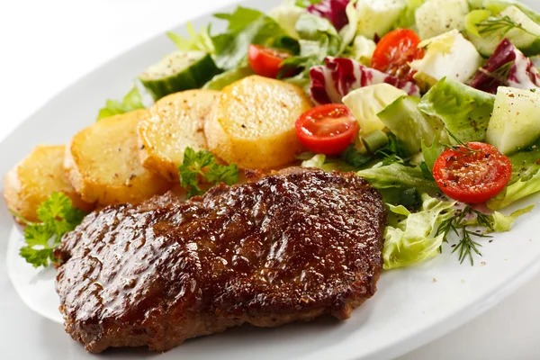 Beefsteak grillé, pommes de terre cuites au four et légumes — Photo