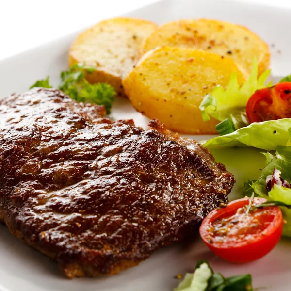 Bife grelhado, batatas assadas e legumes — Fotografia de Stock