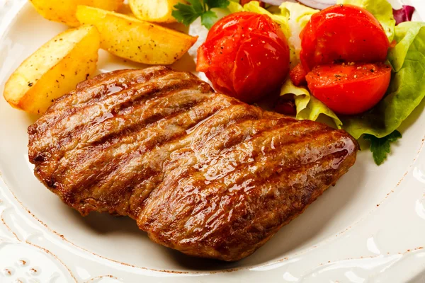 Steak vom Grill, Bratkartoffeln und Gemüsesalat — Stockfoto