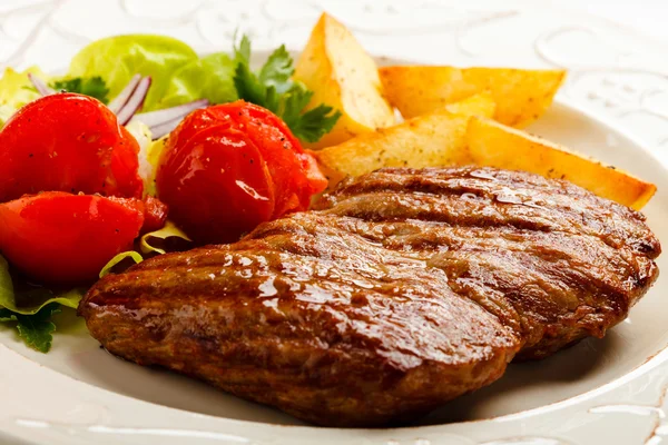 Steak grillé, pommes de terre cuites au four et salade de légumes — Photo