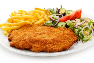 Fried pork chop, French fries and vegetables clipart