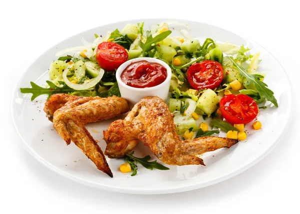 Крылышки на гриле с соусом и овощным салатом — стоковое фото