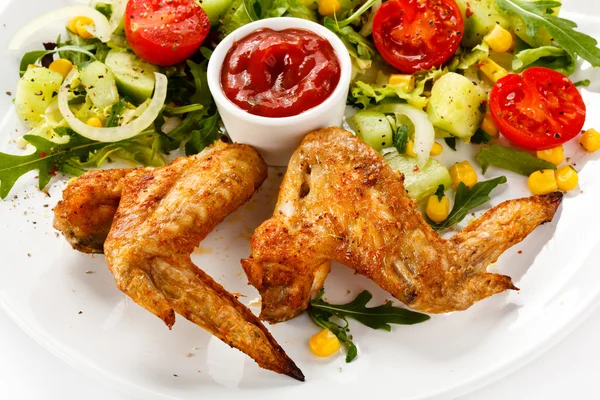 Ailes de poulet grillées avec sauce et salade de légumes — Photo