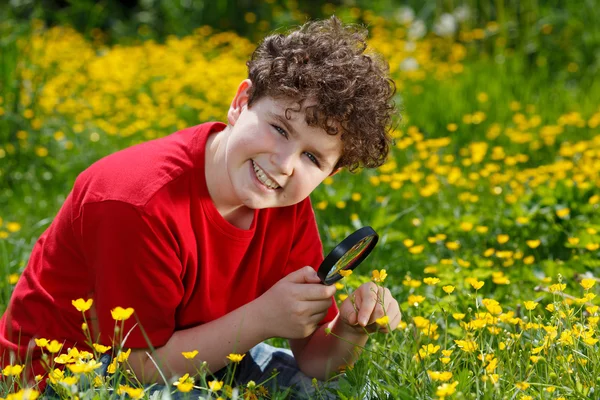 Boy looking through magnifying glass — Stock Photo, Image