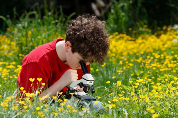 Boy using microscope outdoor — Stock Photo, Image