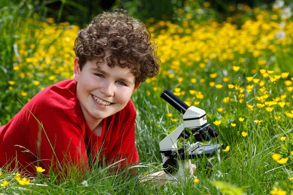 Boy using microscope outdoor — Stock Photo, Image