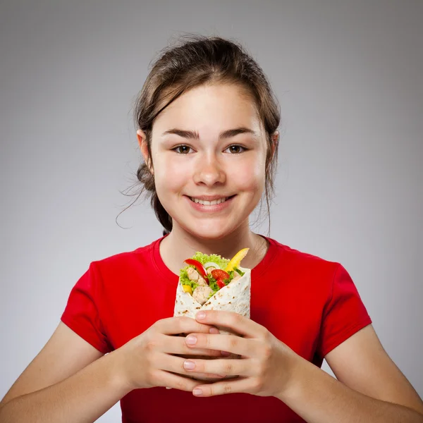 女の子は、大きなサンドイッチを食べて — ストック写真