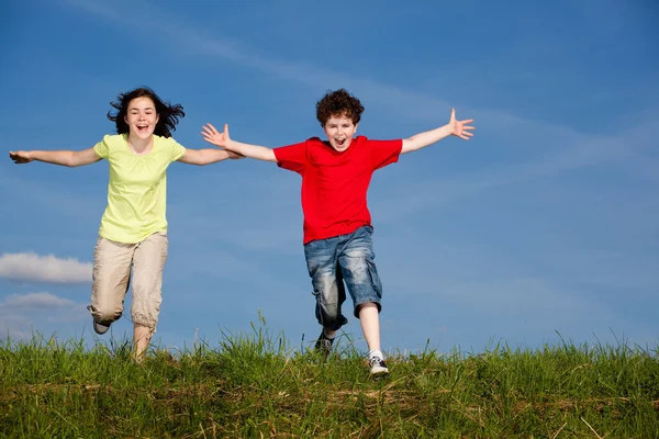 Ragazza e ragazzo saltare, correre all'aperto — Foto Stock