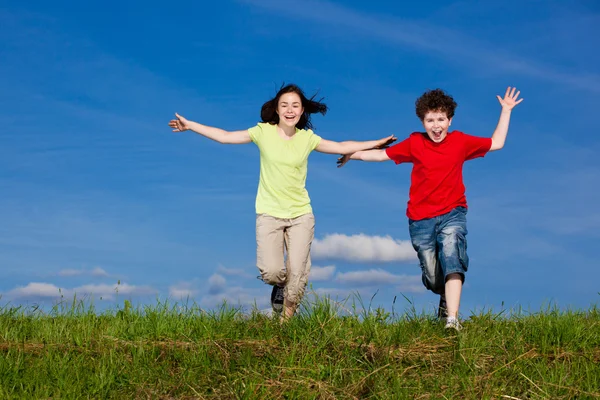 Girl and boy jumping, running outdoor — Stock Photo, Image