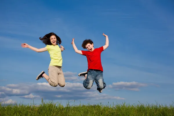 Ragazza e ragazzo saltare, correre all'aperto — Foto Stock