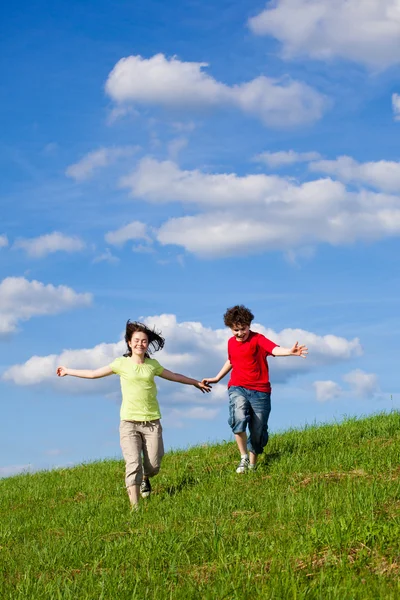 Ragazza e ragazzo saltare, correre all'aperto — Foto Stock