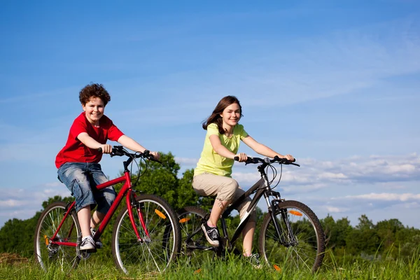 Meisje en jongen fietsen — Stockfoto