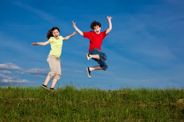 Ragazza e ragazzo saltare, correre all'aperto — Foto Stock