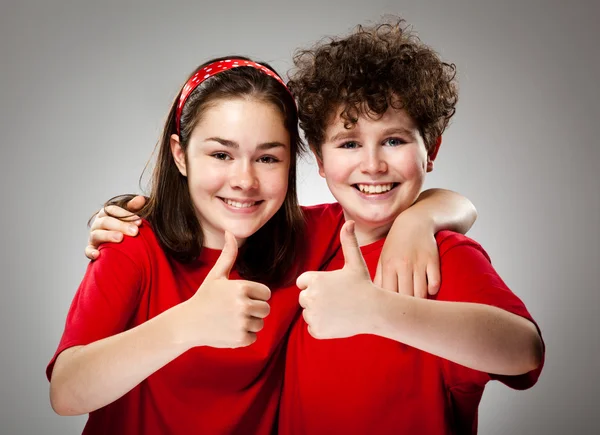 Chica y niño mostrando pulgares hacia arriba — Foto de Stock